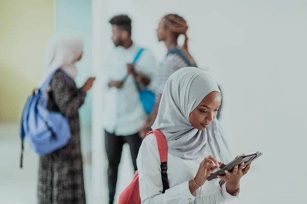 Étudiante africaine avec un groupe d'amis en arrière-plan portant des vêtements traditionnels du hijab islamique. Mettre l'accent sur la sélection — Photo