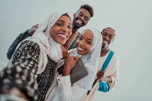Un grupo de estudiantes multiétnicos se toman una selfie con un teléfono inteligente sobre un fondo blanco. Enfoque selectivo —  Fotos de Stock