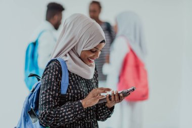 Geleneksel İslami tesettüre bürünmüş bir grup arkadaşı olan Afrikalı bir kız öğrenci. Odaklanma seç 