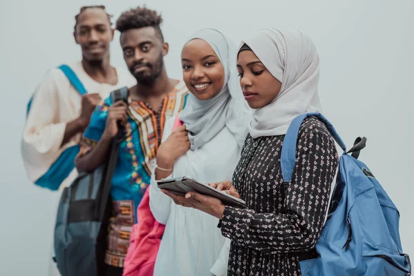 Foto de um grupo de estudantes africanos felizes conversando e se reunindo trabalhando em meninas de lição de casa vestindo hijab muçulmano sudanês tradicional — Fotografia de Stock