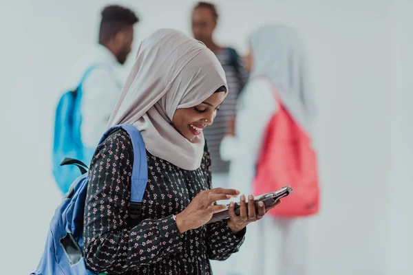 Geleneksel İslami tesettüre bürünmüş bir grup arkadaşı olan Afrikalı bir kız öğrenci. Odaklanma seç 