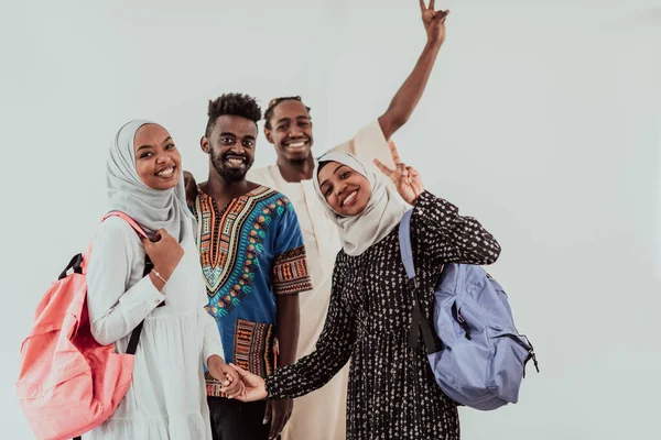 Egy csoport boldog afrikai diák, akik beszélgetnek és csapatmegbeszélést folytatnak, együtt dolgoznak a házi feladaton, lányok, akik szudáni muszlim hidzsáb divatot viselnek. — Stock Fotó