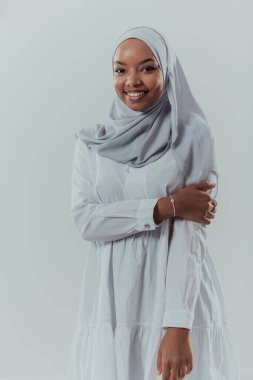 Beyaz arka planda geleneksel İslami kıyafetler giyen modern Müslüman afro güzelliğin portresi. Seçici odak 