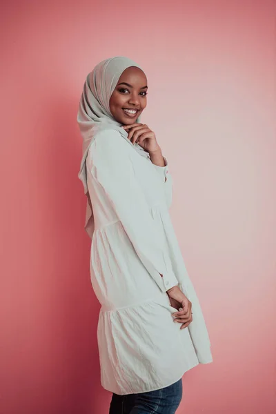 Portrait de jeune afro-musulman moderne portant des vêtements islamiques traditionnels sur fond plastique rose. Concentration sélective — Photo
