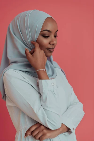 Portrait of young modern muslim afro beauty wearing traditional islamic clothes on plastic pink background. Selective focus — Stock Photo, Image