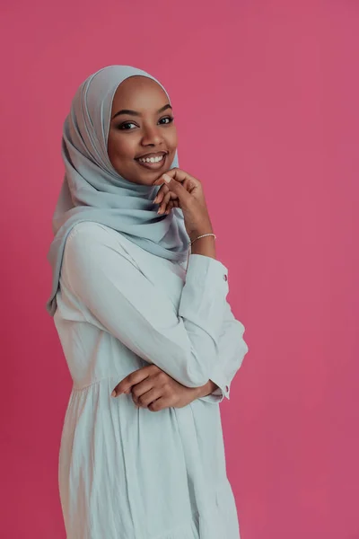 Portret młodego współczesnego muzułmanina afro piękna noszącego tradycyjne islamskie ubrania na plastikowym różowym tle. Skupienie selektywne — Zdjęcie stockowe