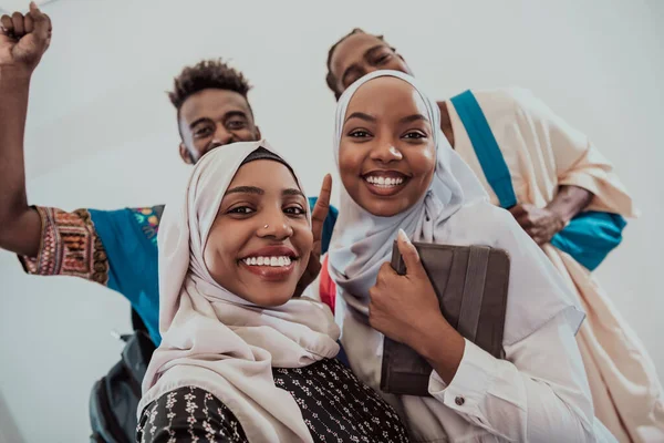 Um grupo de estudantes multiétnicos tirar uma selfie com um smartphone em um fundo branco. Foco seletivo — Fotografia de Stock