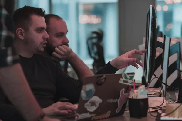Фото трех мужчин, пристально смотрящих на компьютер, сидящих в современном офисе. Селективный фокус — стоковое фото