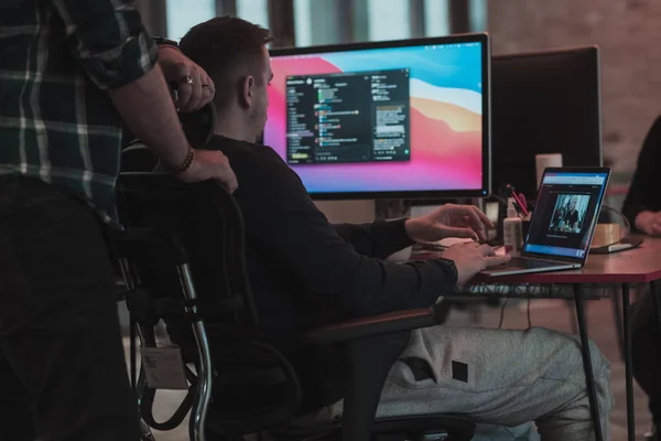 Een foto van drie mannen die aandachtig naar een computer staren terwijl ze in een modern kantoor zitten. Selectieve focus — Stockfoto