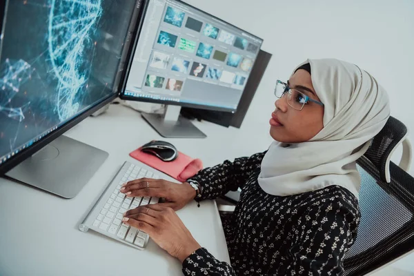 Jeune femme d'affaires musulmane moderne afro-américaine portant un foulard dans un bureau lumineux créatif avec un grand écran. — Photo