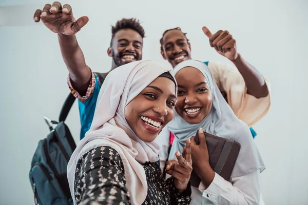 A group of multiethnic students take a selfie with a smartphone on a white background. Selective focus — Stock Photo, Image