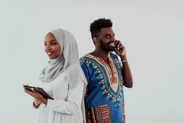 Joven mujer del equipo empresarial africano que usa ropa tradicional sudan muslim hijab usando tableta aislada en pareja de estudiantes de fondo blanco —  Fotos de Stock