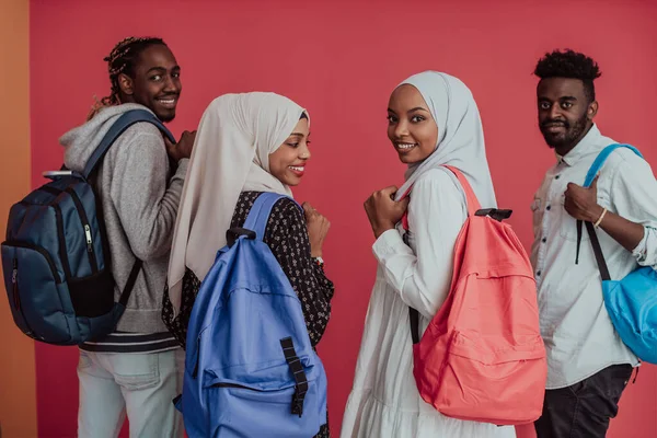 배낭을 찬 아프리카 무슬림 학생들 이 분홍색 배경 위에 포즈를 취하고 있습니다. 학교 교육이라는 개념. — 스톡 사진