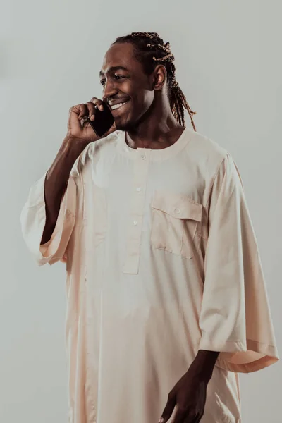 アフリカ人男性がスマートフォンを使ってスーダンの伝統的な服を着て. — ストック写真