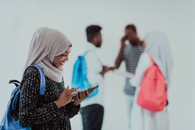 Geleneksel İslami tesettüre bürünmüş bir grup arkadaşı olan Afrikalı bir kız öğrenci. Odaklanma seç 