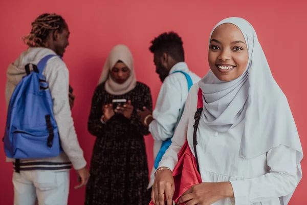 Un grupo de estudiantes musulmanes africanos con mochilas posando sobre un fondo rosa. el concepto de educación escolar. — Foto de Stock