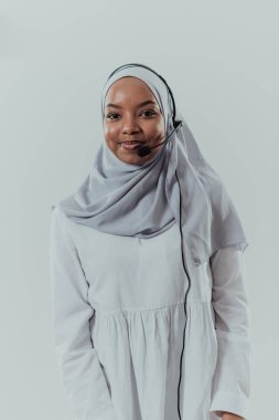 Türbanlı Afrikalı Müslüman kadın, müşteri temsilcisi, telefon kulaklıklı iş kadını, beyaz arka planda, modern, aydınlık çağrı merkezinde müşteriyle çevrimiçi olarak yardım ve destek veriyor.