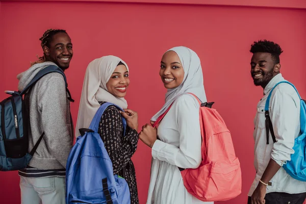 Grupa afrykańskich muzułmańskich studentów z plecakami pozującymi na różowym tle. koncepcja kształcenia szkolnego. — Zdjęcie stockowe