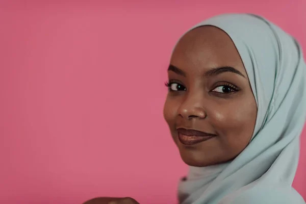 Potret muda muslim muda cantik afro mengenakan pakaian islamik tradisional di latar belakang plastik merah muda. Fokus selektif — Stok Foto
