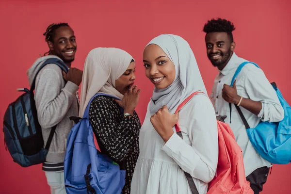 Um grupo de estudantes muçulmanos africanos com mochilas posando em um fundo rosa. o conceito de educação escolar. — Fotografia de Stock