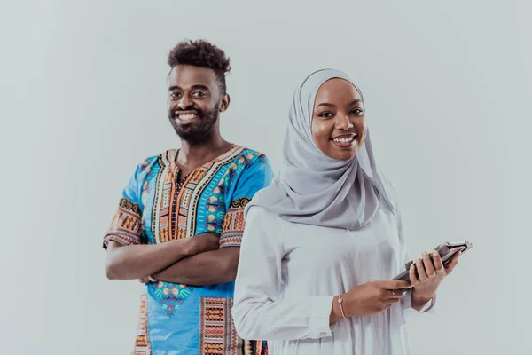 若いアフリカのビジネスチームの女性は伝統的なスーダンのイスラム教徒のヒジャーブの服を着て白い背景の学生のカップルに隔離されたタブレットコンピュータを使用して — ストック写真