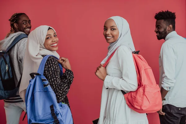 Egy csoport afrikai muszlim diák hátizsákkal, rózsaszín háttéren pózolva. az iskolai oktatás fogalma. — Stock Fotó