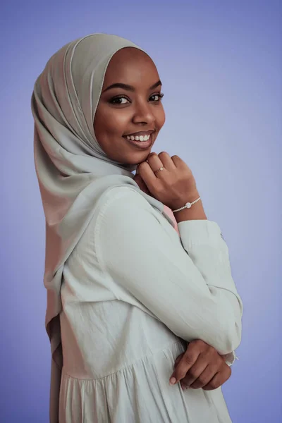 Porträtt av unga moderna muslimska afro skönhet bär traditionella islamiska kläder på plast rosa bakgrund. Selektiv inriktning Royaltyfria Stockbilder