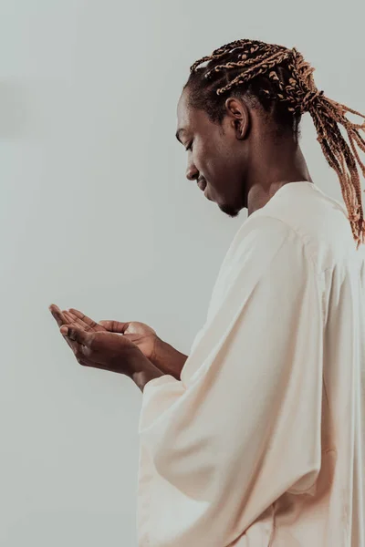 Bonito jovem africano muçulmano homem fazendo tradicional Fatiha oração a Deus enquanto vestindo uma roupa de moda tradicional do Sudão em estúdio — Fotografia de Stock