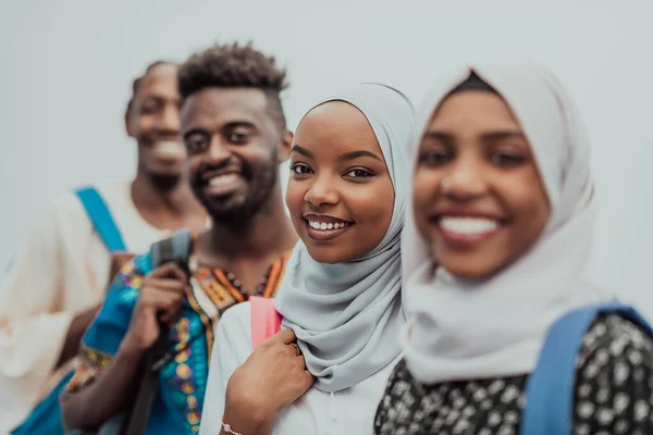 Foto de un grupo de estudiantes africanos felices conversando y reuniéndose juntos trabajando en las niñas de la tarea usando el tradicional hiyab musulmán sudanés —  Fotos de Stock