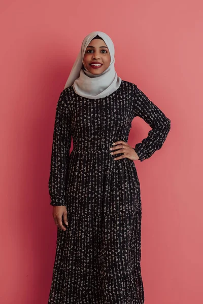 Portrait of young modern muslim afro beauty wearing traditional islamic clothes on plastic pink background. Selective focus — Stock Photo, Image