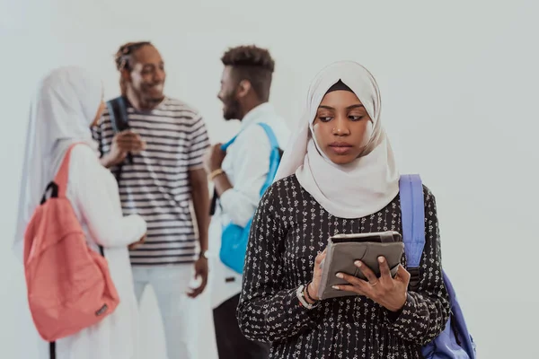 Africká studentka se skupinou přátel v pozadí nosí tradiční islámské hidžáb oblečení. Vybrat zaměření — Stock fotografie