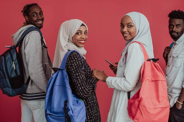Eine Gruppe afrikanischer muslimischer Studenten mit Rucksäcken posiert auf rosa Hintergrund. das Konzept der Schulbildung. — Stockfoto