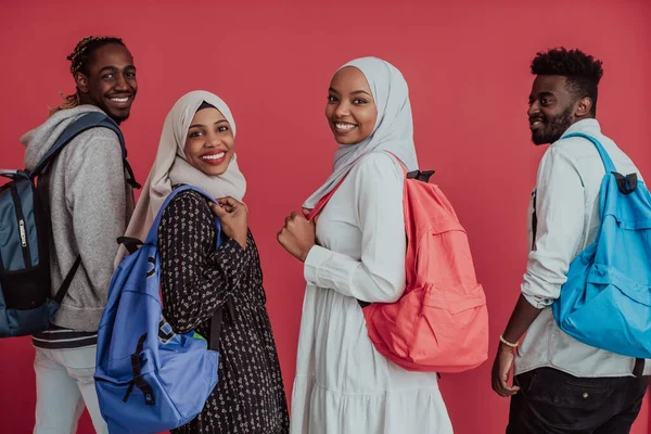 Egy csoport afrikai muszlim diák hátizsákkal, rózsaszín háttéren pózolva. az iskolai oktatás fogalma. — Stock Fotó