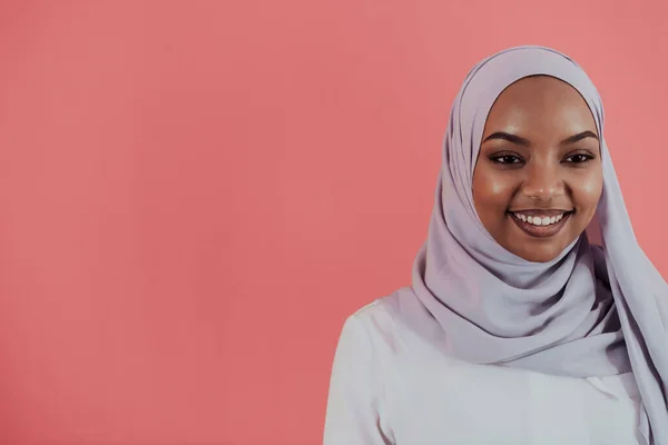 Videograf in digitalem Studio nimmt Video auf professioneller Kamera auf, indem er Muslimin mit Hijab-Schal auf rosa Hintergrund filmt. — Stockfoto