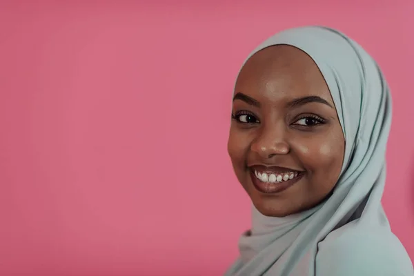 Porträtt av unga moderna muslimska afro skönhet bär traditionella islamiska kläder på plast rosa bakgrund. Selektiv inriktning — Stockfoto
