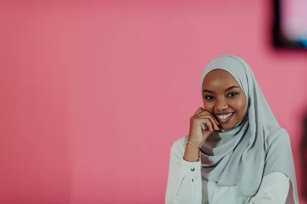 Portrait of young modern muslim afro beauty wearing traditional islamic clothes on plastic pink background. Selective focus — Stock Photo, Image