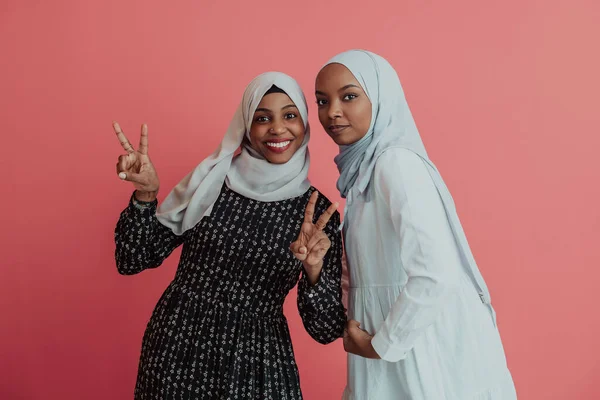 Porträtt av två unga moderna muslim afro skönhet bär traditionella islamiska kläder på rosa bakgrund — Stockfoto