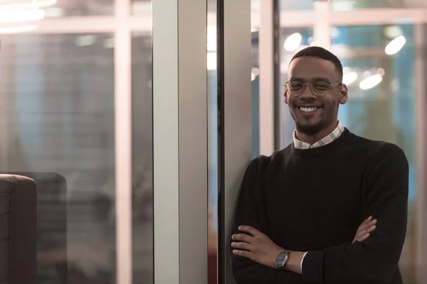 Афроамериканец смотрит на камеру, стоящую в холле офиса. Портрет команды менеджеров мультикультурных компаний. — стоковое фото