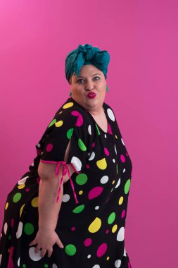 Artı, modaya uygun makyajlı seksi model kadın, stüdyoda pembe arka planda poz veren siyah kısa elbiseli şık sarışın. Yüksek kalite fotoğraf