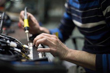 Endüstriyel işçiler bir fabrikada lehimleme malzemesi kabloları üretiyor. Seçici odak