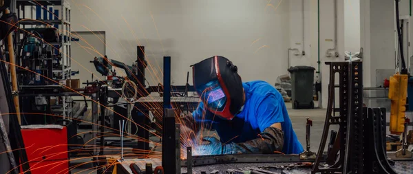 İçerideki fabrikada çalışan Profesyonel Ağır Sanayi Kaynakçısı, Kask Giyiyor ve Kaynak Yapmaya Başlıyor. Seçici Odaklanma — Stok fotoğraf