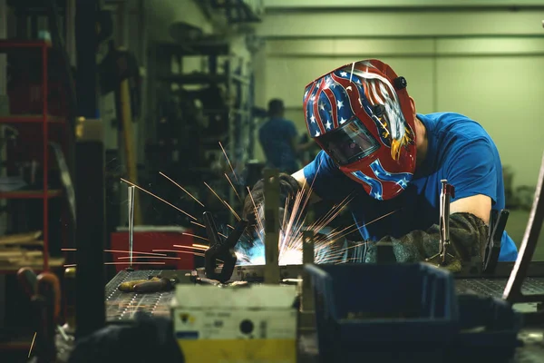 Professional Heavy Industry Welder Working Inside factory, Wears Helmet and Starts Welding. Selective Focus