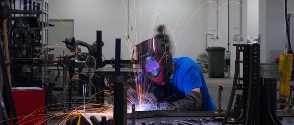 Professional Heavy Industry Welder Working Inside factory, Wears Helmet and Starts Welding. Selective Focus — Fotografia de Stock