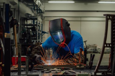 Professional Heavy Industry Welder Working Inside factory, Wears Helmet and Starts Welding. Selective Focus