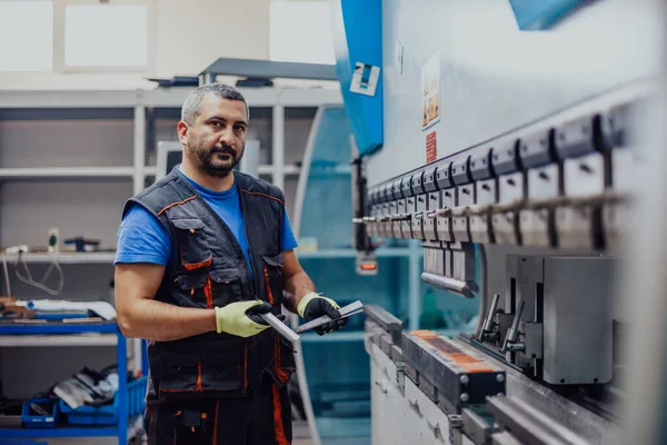 A smart factory worker or engineer makes machines in a production workshop. The concept of industry and engineering. Selective focus — Foto de Stock