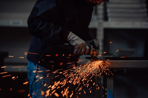 重工業エンジニアリング工場産業労働者と内部角度研削盤を使用して金属チューブを切断します。安全制服とハード帽子製造金属構造の請負業者. — ストック写真