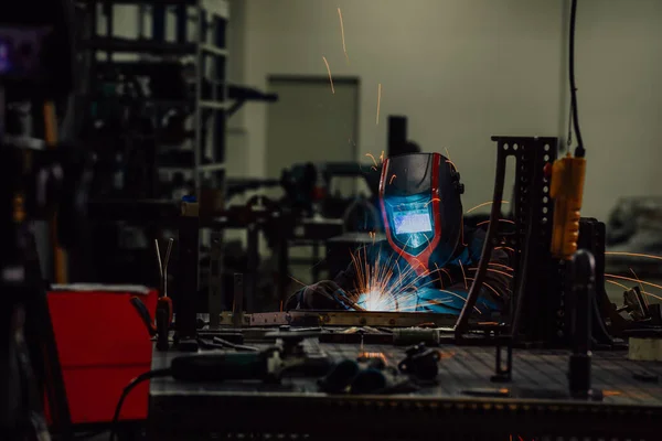 Professional Heavy Industry Welder Working Inside factory, Wears Helmet and Starts Welding. Selective Focus — Stok fotoğraf