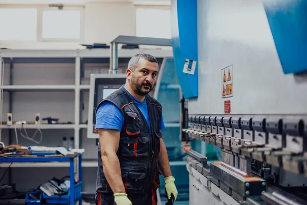 A smart factory worker or engineer makes machines in a production workshop. The concept of industry and engineering. Selective focus —  Fotos de Stock