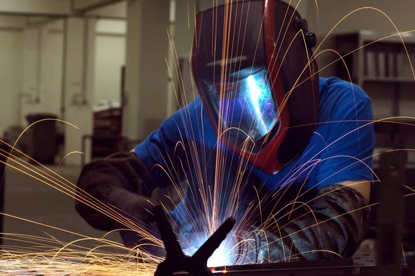 Professional Heavy Industry Welder Working Inside factory, Wears Helmet and Starts Welding. Selective Focus — Stok fotoğraf