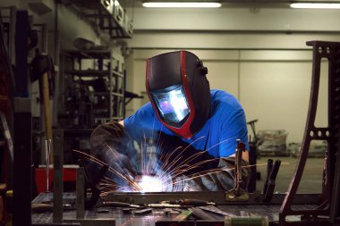 Professional Heavy Industry Welder Working Inside factory, Wears Helmet and Starts Welding. Selective Focus